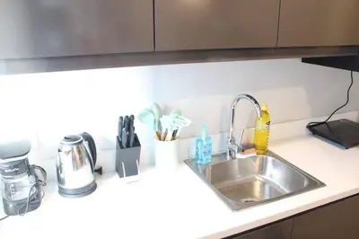 a kitchen counter top with a sink and a counter top at A2J Luxury BGC Balcony Suite Near SM AURA Taguig in Manila