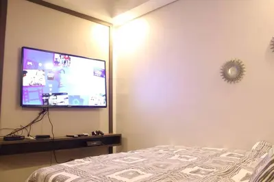 a bedroom with a bed and a flat screen tv at A2J Luxury BGC Balcony Suite Near SM AURA Taguig in Manila