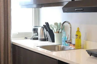 a kitchen counter with a sink and a window at A2J Luxury BGC Balcony Suite Near SM AURA Taguig in Manila