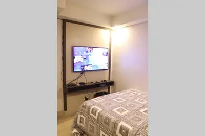 a bedroom with a bed and a flat screen tv at A2J Luxury BGC Balcony Suite Near SM AURA Taguig in Manila