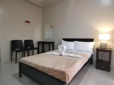 a bedroom with a bed with a white towel on it at G Square Residences in Manila