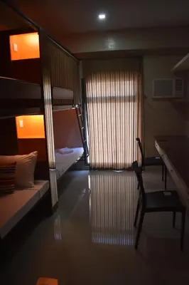 a bedroom with bunk beds and a desk and a chair at G Square Residences in Manila