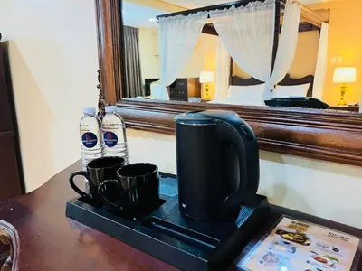 a coffee maker and cups on a tray on a table at Arzo Hotel Manila in Manila