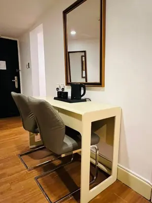 a desk with a chair and a mirror on a wall at Arzo Hotel Manila in Manila