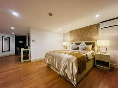 a large bedroom with a large bed and wooden floors at Arzo Hotel Manila in Manila