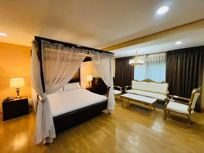 a bedroom with a canopy bed and a couch at Arzo Hotel Manila in Manila