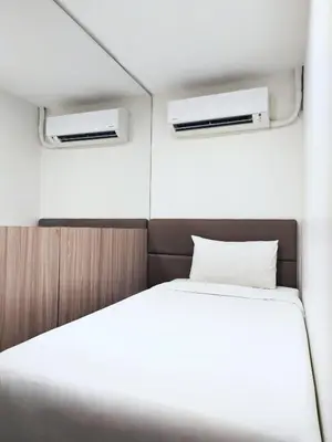 a bed in a small room with two windows at Anex Hotel in Manila