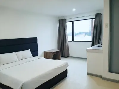 a bedroom with a bed and a bathroom with a window at Anex Hotel in Manila