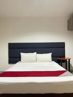 a bedroom with a large bed with a blue headboard at Anex Hotel in Manila