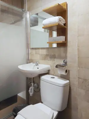 a bathroom with a white toilet and a sink at Anex Hotel in Manila