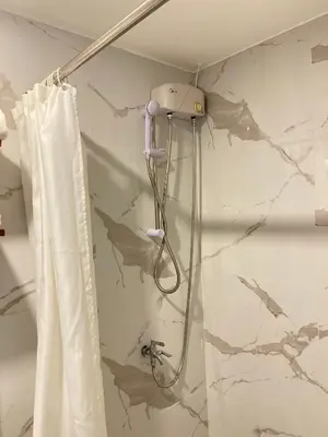 a shower with a blow dryer on a wall at Anex Hotel in Manila