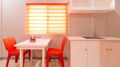 a kitchen with a table and two chairs and a sink at RedDoorz near Christ the King Medical Center in Manila