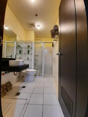 a bathroom with a toilet and a sink and a shower at The Rochester in Manila