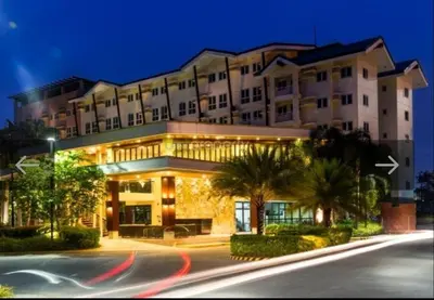 a large building with palm trees in front of a street at The Rochester in Manila