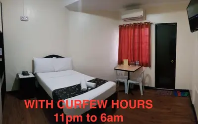 a small room with a bed and a small table at Grand Traveler Suite Inc in Manila