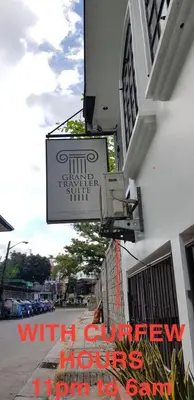 a sign on the side of a building on a street at Grand Traveler Suite Inc in Manila