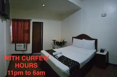 a bed in a hotel room with the words tom to slam at Grand Traveler Suite Inc in Manila