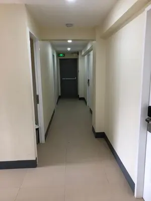an empty hallway in a building with a door at Snoozeph in Manila