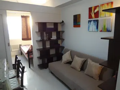 a living room with a couch and a shelf at manila sea view homes 21 in Manila