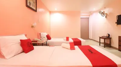 a room with two beds with red and white pillows at RedDoorz Plus @ Chinatown Binondo in Manila