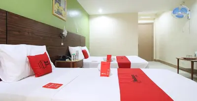 a hotel room with two beds with red and white pillows at RedDoorz Plus @ Chinatown Binondo in Manila
