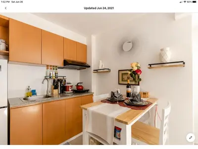a kitchen with wooden cabinets and a table with flowers at The Rustic Haven-1 in Manila