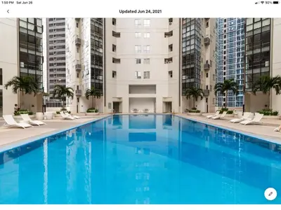 a large swimming pool in a building with tall buildings at The Rustic Haven-1 in Manila
