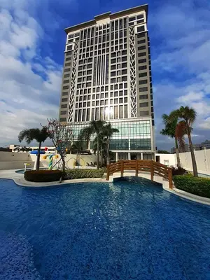 a large building with a pool in front of a building at The Excelsior Hotel Las Piñas in Manila