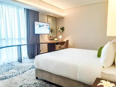 a hotel room with a bed and a television at The Excelsior Hotel Las Piñas in Manila