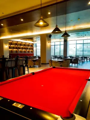 a pool table in a room with a restaurant at The Excelsior Hotel Las Piñas in Manila