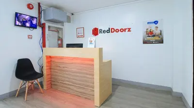 a red door in a room with a chair at RedDoorz near Zobel Roxas St in Manila