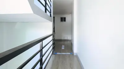 a hallway with white walls and wood flooring at RedDoorz near Zobel Roxas St in Manila