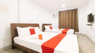 a bedroom with two beds with red and white sheets at RedDoorz near Zobel Roxas St in Manila