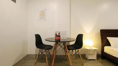 a table and two chairs in a room with a bed at RedDoorz near Zobel Roxas St in Manila