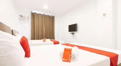 a hotel room with two beds and a tv at RedDoorz near Zobel Roxas St in Manila