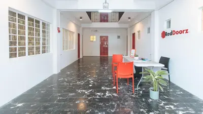 a dining room with a table and red chairs at RedDoorz at VCloud Hills near De La Salle Dasmarinas Cavite in Dasmariñas