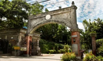 an archway in a park with bushes and trees at RedDoorz at VCloud Hills near De La Salle Dasmarinas Cavite in Dasmariñas
