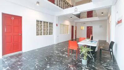 a room with a red door and a table and chairs at RedDoorz at VCloud Hills near De La Salle Dasmarinas Cavite in Dasmariñas