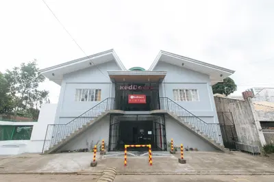 a white building with a staircase in front of it at RedDoorz at VCloud Hills near De La Salle Dasmarinas Cavite in Dasmariñas