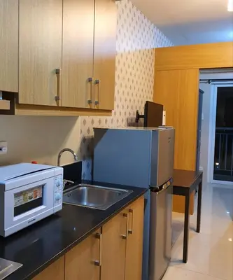 a kitchen with a sink and a refrigerator at SHELL RESIDENCES in Manila