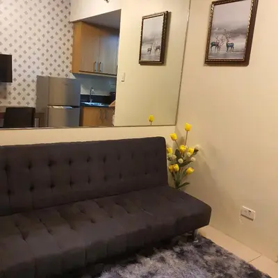 a couch in a living room with a kitchen at SHELL RESIDENCES in Manila