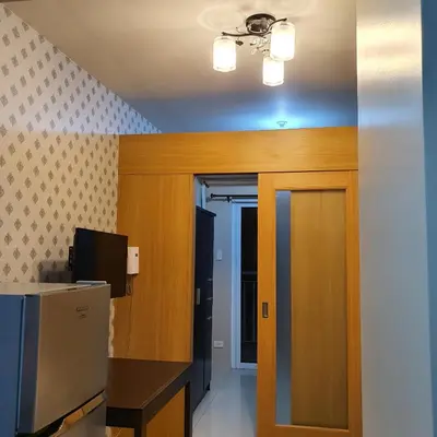 a room with a door leading to a kitchen with a television at SHELL RESIDENCES in Manila