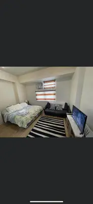 a bedroom with a bed and a laptop on a desk at Khentdrick's Place at Holland Park Southwoods in Biñan