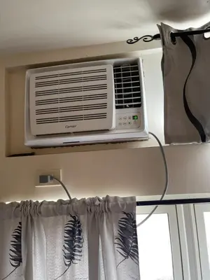 a air conditioner on a shelf above a window at Khentdrick's Place at Holland Park Southwoods in Biñan