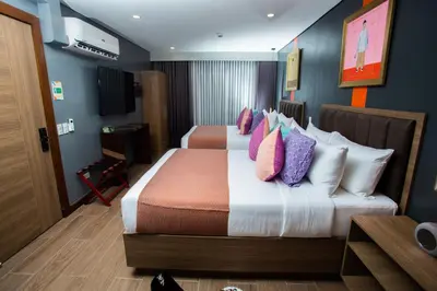 a hotel room with two beds with colorful pillows at UNWND Flats in Manila