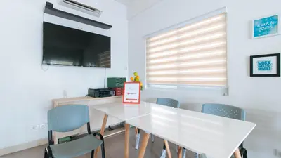 a white dining room with a white table and chairs at RedDoorz Plus at Alpina Heights Paranaque in Manila