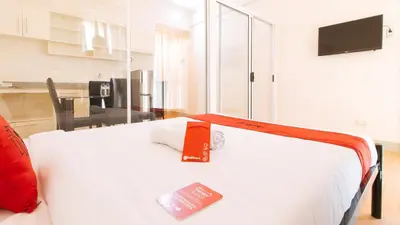 a bedroom with a bed with a book on it at RedDoorz Plus at Alpina Heights Paranaque in Manila