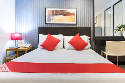 a bedroom with a large bed with red pillows at Orange Nest Hotel in Manila