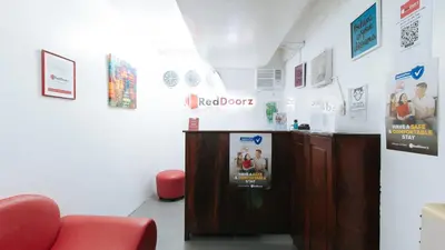 a waiting room with a desk and a red chair at RedDoorz near Pasay Rotonda in Manila