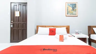 a bedroom with a bed with a red blanket on it at RedDoorz near Pasay Rotonda in Manila
